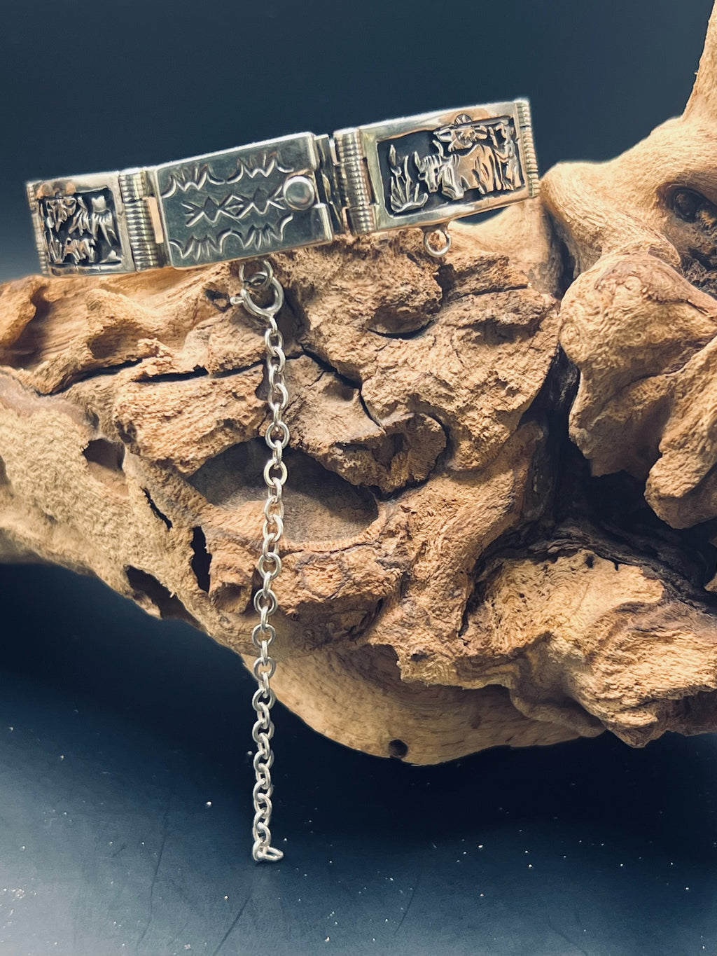 Sterling silver, hand-fabricated panel bracelet depicting a bull and farmer, as well as a push-to-open clasp with geometric designs.